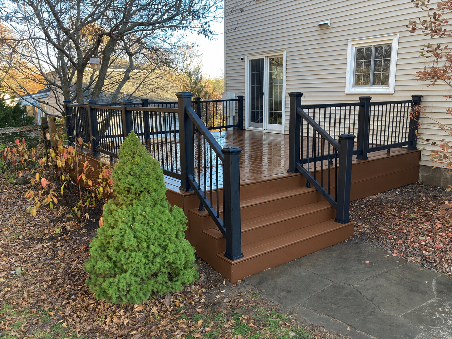 Trex Saddle composite deck with Trex Charcoal Black railings and matching steps at dusk